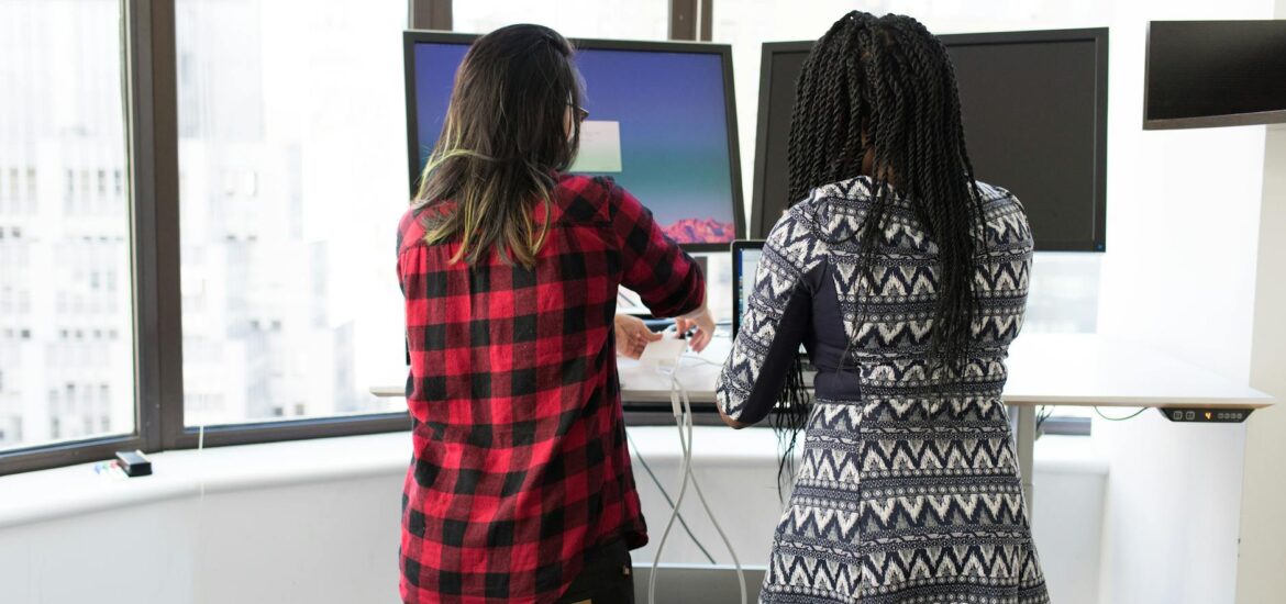 two women standing in front of television